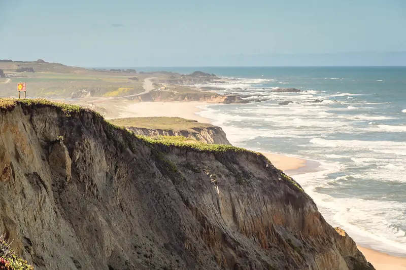 Photo of eroded bluffs and surf along the coast near Pescadero